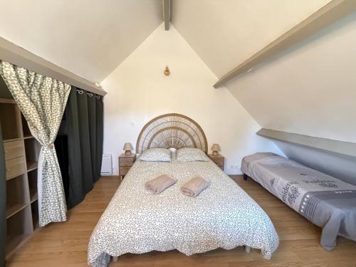 a bedroom with a bed with two pillows on it at Le Ptit Roc, cocon cosy in Chailles