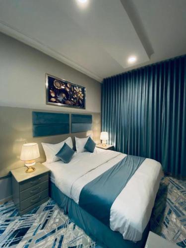 a bedroom with a large bed with blue and white sheets at غرفة وصالة في موقع مميز ترخيص ضيافة خاصة in Khamis Mushayt
