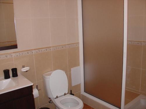 Un pequeño baño con inodoro y ducha. en Apartamento Sol e Mar 2, en Monte Gordo