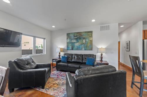 a living room with black leather furniture and a flat screen tv at 57 Robber's Roost in Moab
