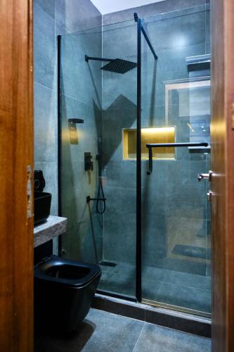 a bathroom with a glass shower with a toilet at Revkon Apartments in Abuja