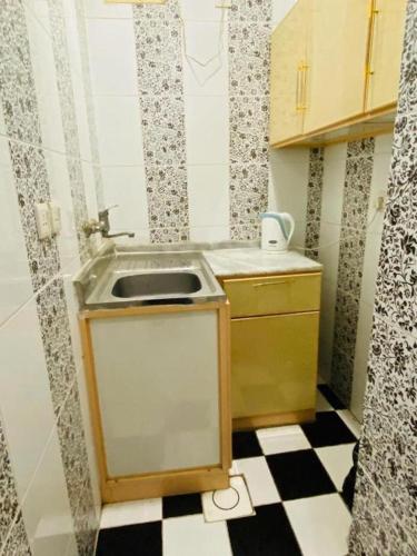 a small kitchen with a sink and a checkered floor at غرفة وصالة في موقع مميز ترخيص ضيافة خاصة in Khamis Mushayt