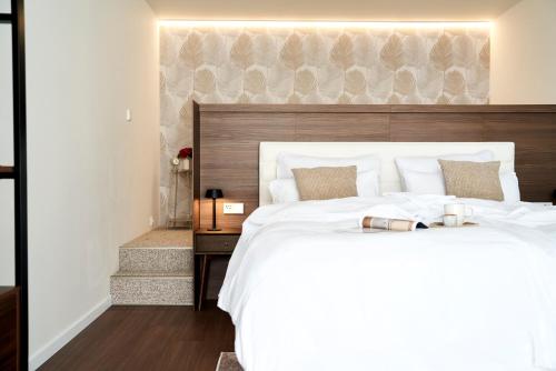 a bedroom with a large white bed with a wooden headboard at Stadtmauerloft - Premium Apartment in Eisenstadt