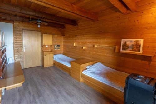 a room with two beds in a wooden cabin at Raj pod vrhom in Poljane nad Škofjo Loko