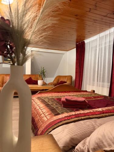 a bedroom with a bed and a vase of flowers at Kalna Raskumu Apartamenti in Vecpiebalga