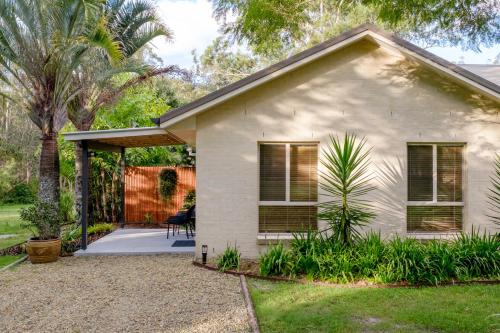 a small white house with a porch at Simple Style Among the Gums 