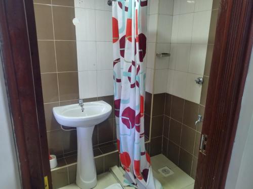 a bathroom with a sink and a shower curtain at Gee homestay Kakamega in Kakamega