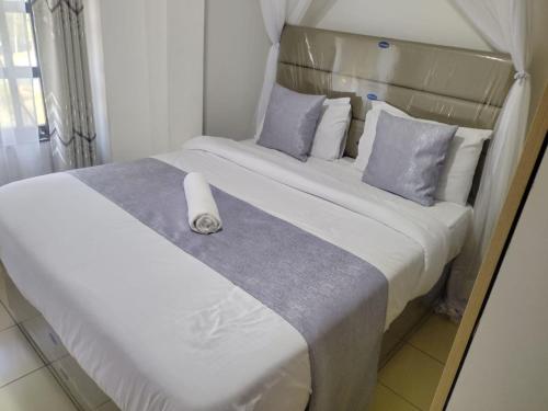 a large white bed with a white candle on it at Gee homestay Kakamega in Kakamega