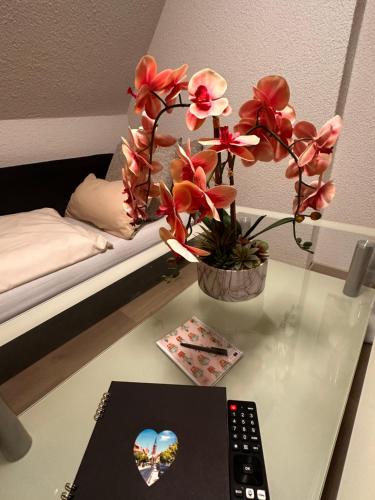a desk with a remote control and flowers on it at Ferienwohnung mit Schminktisch 2OG in Gräfenhainichen