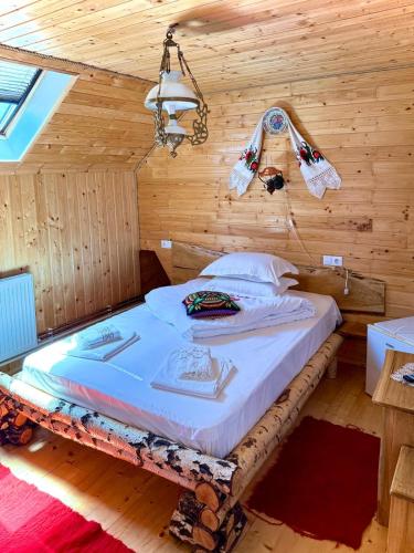 a bedroom with a bed in a wooden room at Domeniul Ursului in Vadu Izei