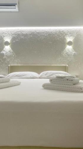 a white bed with two white towels on it at Dream Wellness Suite in Barletta
