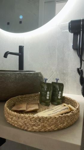 a bathroom counter with a basket with two toothbrushes at Dream Wellness Suite in Barletta