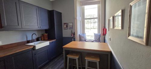 a kitchen with blue cabinets and a sink and a counter at Bishop Street Apartment in Rothesay