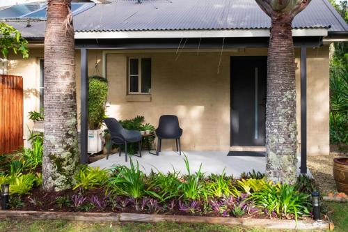 a patio with two chairs and a table in front of a house at Simple Style Among the Gums 