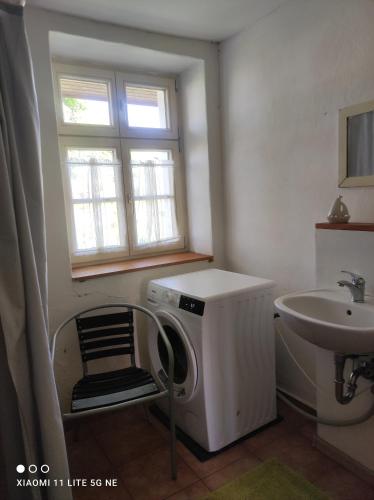 a bathroom with a washing machine and a sink at Schwalbennest 