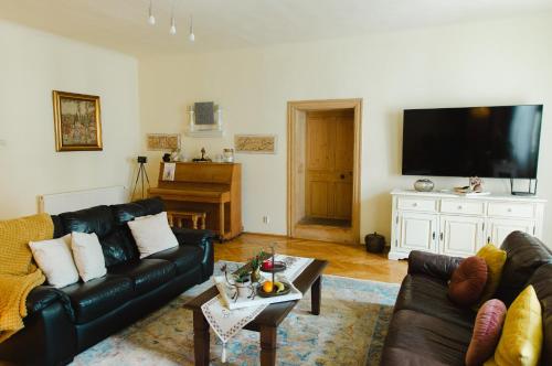 a living room with two couches and a flat screen tv at Casa Crown in Sighişoara
