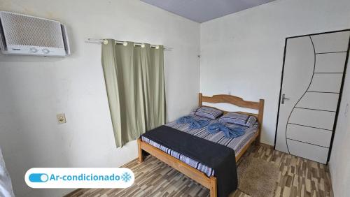 a small bedroom with a bed and a window at Casa Vigia 2 Quartos in Vigia