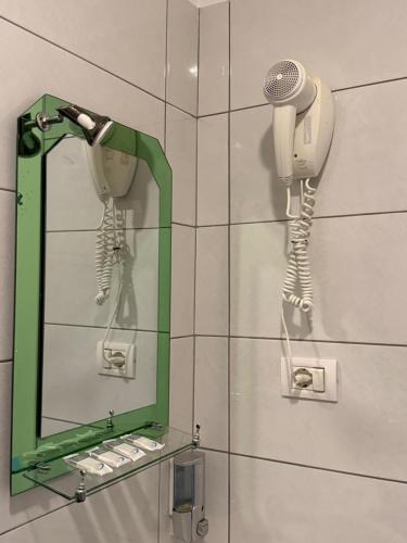 a bathroom with a mirror and a hair dryer at Prestige ESP ROOMS in Poliçan