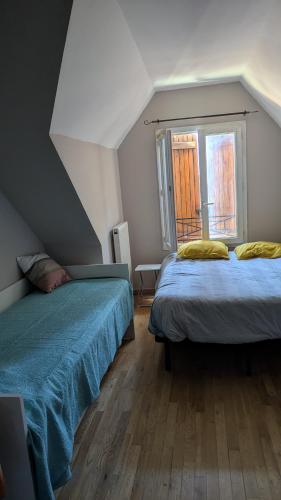 a room with two beds and a window at Le petit cocon in Linas