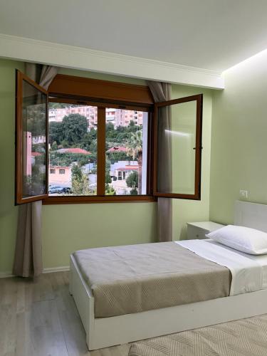 a bedroom with a bed and a large window at Prestige ESP ROOMS in Poliçan