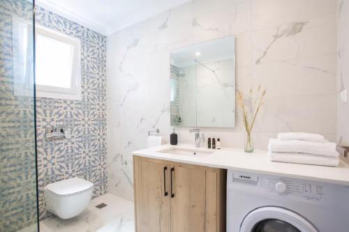 a bathroom with a washing machine and a sink at Dante Home's in Corfu