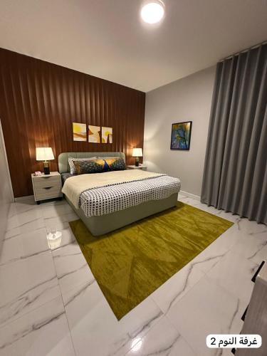 a bedroom with a large bed and a green rug at marjan beach in Dhahran