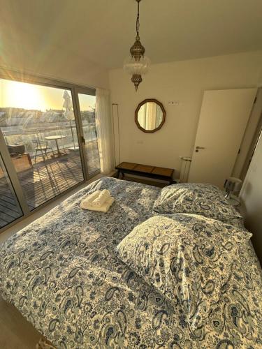 a bedroom with a bed and a large window at OASIS in Buarcos