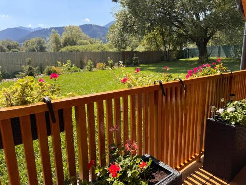 a wooden fence with flowers in a yard at Domček pod Vežami s vírivkou a grilom, pri termálnom kúpalisku in Liptovský Ján