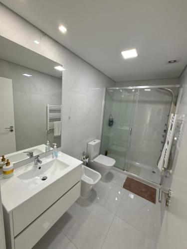 a bathroom with a sink and a toilet and a shower at OASIS in Buarcos