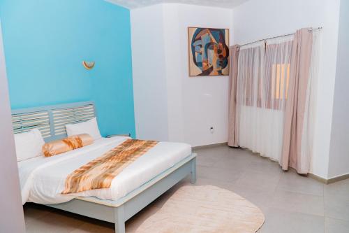 a bedroom with a bed in a blue room at Pericare Évasion Saly Espace exclusivement féminin in Saly Portudal