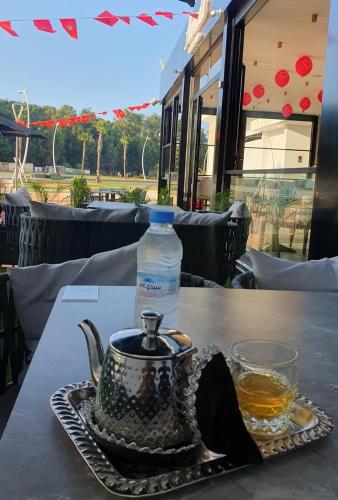 a bottle of water and a tea kettle on a table at Playa 7 in Martil