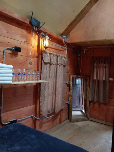 a room with wooden walls and a window and a lamp at Cabañas Ticomulco in Zacatlán