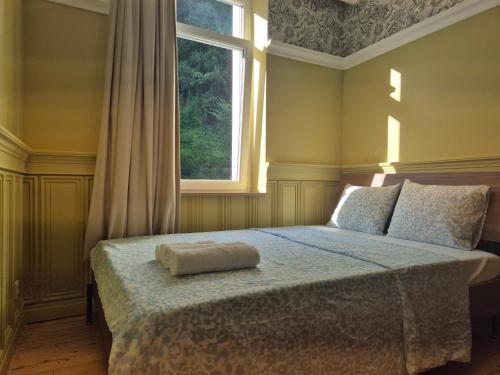 a bedroom with a bed with a window at Small Modern Rooms in Luxembourg