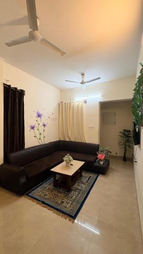 a living room with a black couch and a table at Hotel bella rosa in Chengalpattu