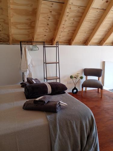 a room with a bed with a chair and a chair at Casa Malbec en Los Molles in Las Lenas
