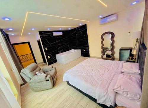 a bedroom with a large bed and two chairs at Dahab Luxury Villa with Private Pool in Al Rama