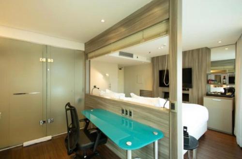a bedroom with a desk and a bed and a mirror at Radisson V Olimpia in São Paulo