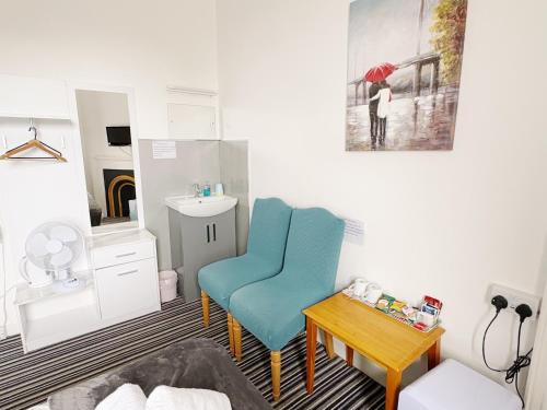 a living room with a blue chair and a table at Edinburgh full bliss in Edinburgh