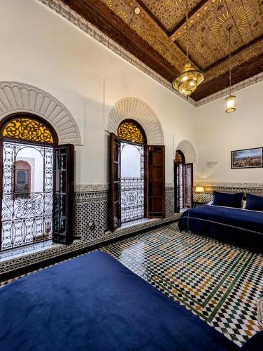 a living room with a bed and two windows at Riad Arabella Fès in Fez