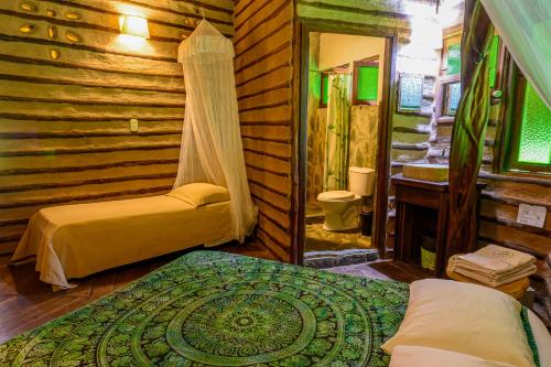 a bedroom with two beds in a log cabin at 3 Cozy TripleDouble Rooms - Trisquel in Restrepo