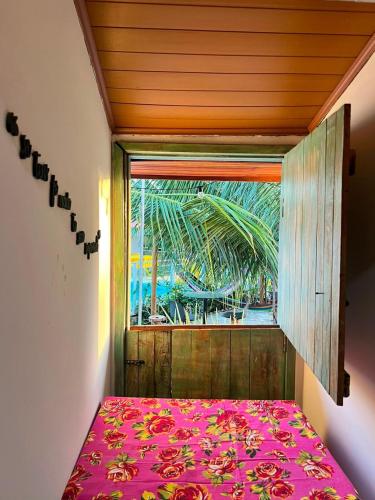 a bed in a room with a window at Casa Velha Hospedagem Jacuípe in Camaçari