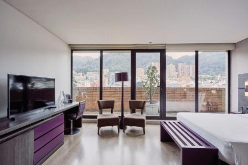 a hotel room with a bed and a tv and a bedroom at Mercure Bogota BH Zona Financiera in Bogotá