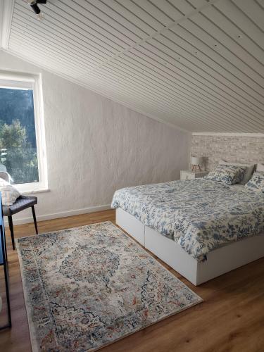 a bedroom with two beds and a window and a rug at The Cherry Tree Place in Góis