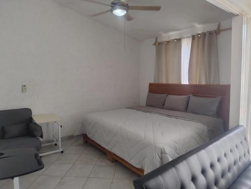 a bedroom with a bed and a couch and a window at Acapulco Diamante - Playa Princess & GNP Arena in Acapulco