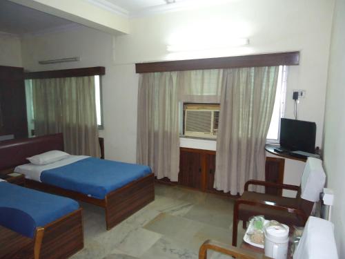 a bedroom with a bed and a desk and a television at Hotel Stafi in Pune