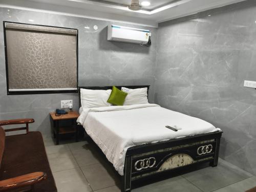 a bedroom with a bed with a green pillow on it at HoTEL MADHAVI PRIME in Guntūr