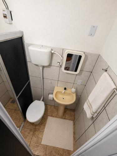 a small bathroom with a toilet and a sink at Ammonite Hostel - Itacaré in Itacaré