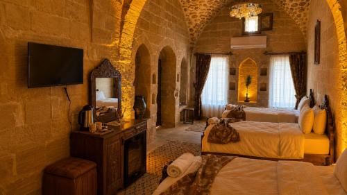 a bedroom with a bed and a tv in a room at Alies Konağı in Mardin
