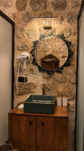 a stone wall with a sink and a mirror at Alies Konağı in Mardin