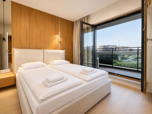 a bedroom with a large white bed and a large window at ApartmentPrestige Central Station in Krakow